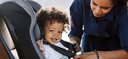 Child being buckled into a car seat