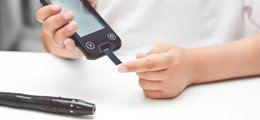 Closeup of hands using glucose monitoring tools