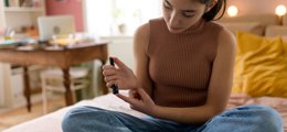 Teen girl using diabetes monitoring equipment