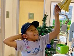 Eli ringing a bell at Cottage Children's Medical Center