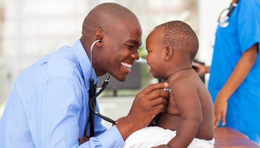 Pediatrician smiling and examining a baby