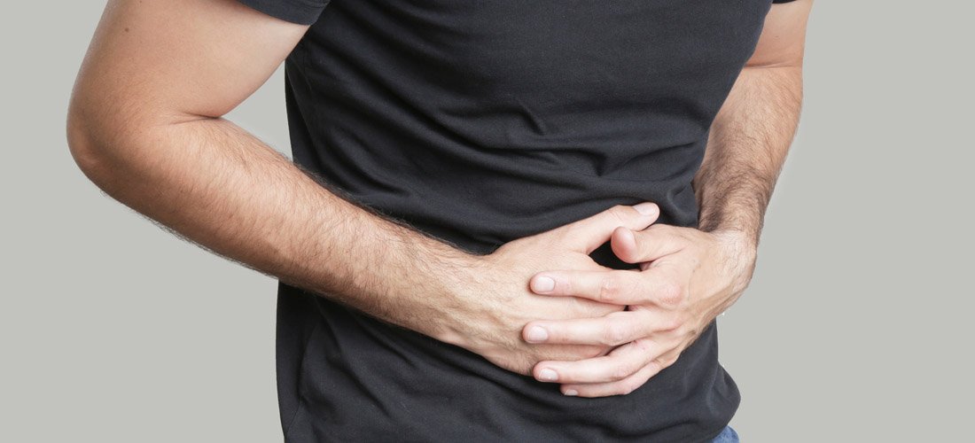 Man in pain holding his lower abdomen