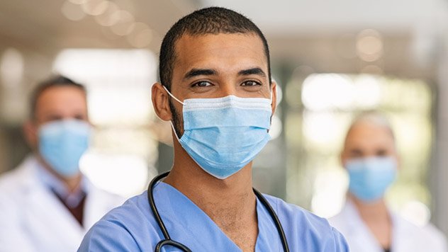 Male nurse wearing a mask and looking at the camera