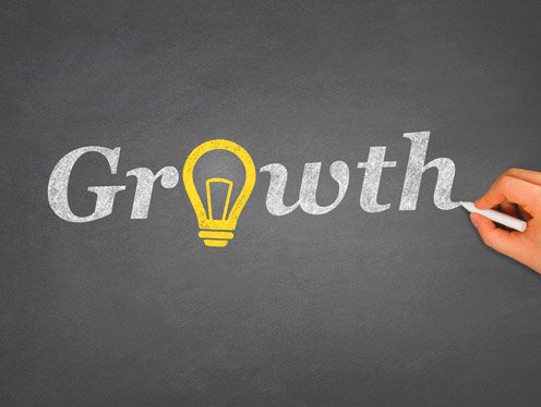 The word growth being drawn on a chalk board