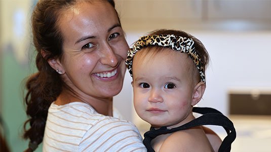 A mother and child smiling in the Grotenhuis Clinic hallway