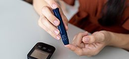 a woman performing a diabetes test on her finger