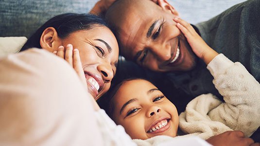 multi-ethnic parents snuggling their son