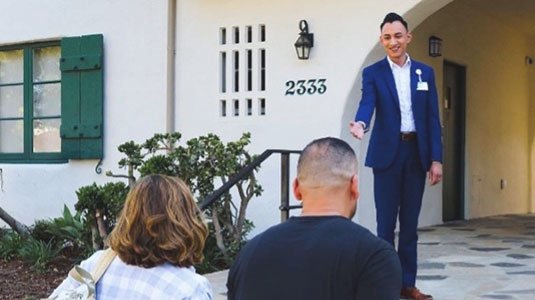 A care giver greeting a family outside of the Cottage Family Suites