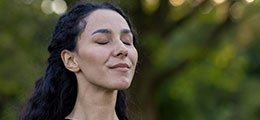 a woman outside taking a deep breath of fresh air