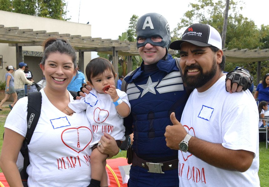 Captain America posing with a family at the NICU Reunion