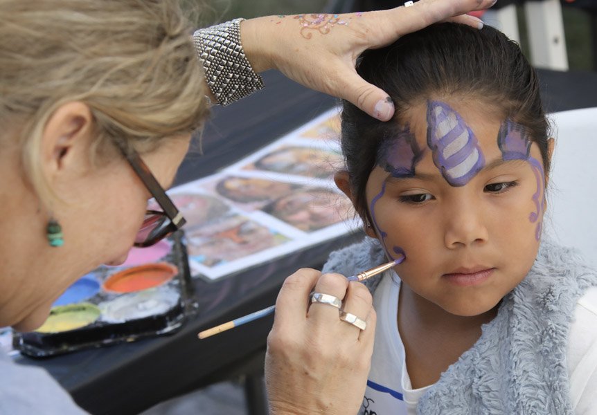 Child enjoying getting their face painted at the NICU Reunion