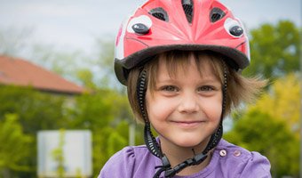 Child smiling and wearing a safety helmet