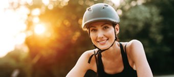 a woman wearing a bike helmet outdoors