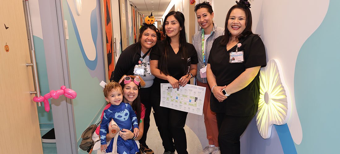 A group of Cottage employees and family in the hallway of the Pediatric Clinic