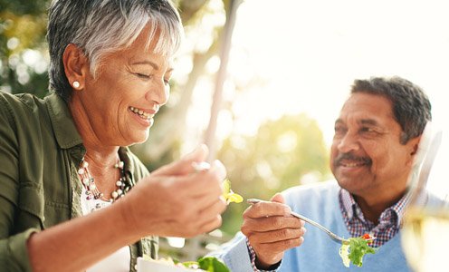 Couple enjoying an outdoor picnic and green salad