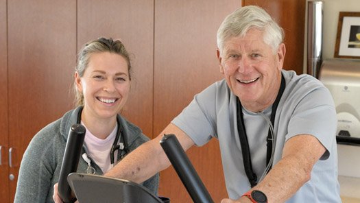 Cardia Rehabiliation Staff with a patient on a stationary bike