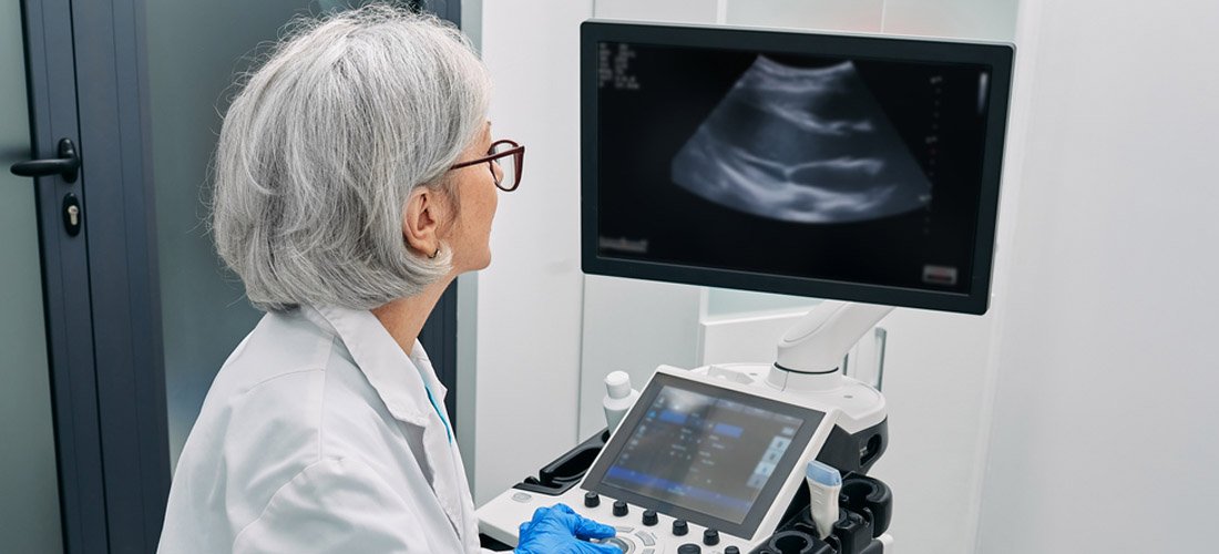 Female provider performing a heart ultrasound on a patient