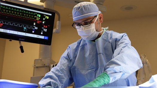 Provider performing a procedure in a surgical room