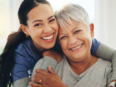 Daughter hugging mother and smiling at the camera