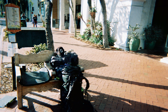 packed belongings next to a public chair