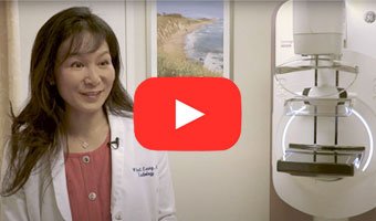 Youtube play button over a photo of Dr. Leung in a room with a mammography machine