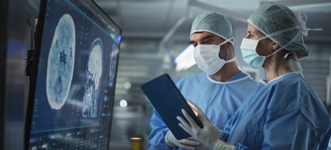 Photo of providers reviewing brain scans on a computer monitor