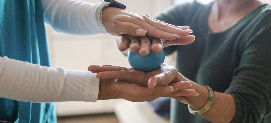 Photo of provider helping a patient with therapy balls