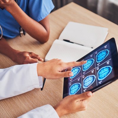 Providers reviewing neurology scans on a tablet screen