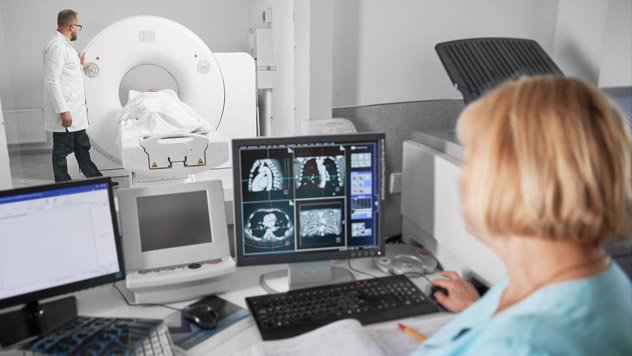 Patient in an MRI machine and providers monitoring results
