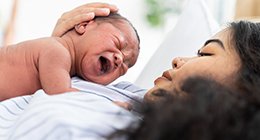 a hispanic newborn with his mother