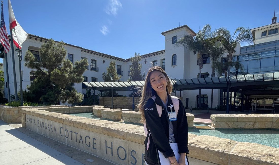 A Cottage Health Pharmacy resident standing in front of Santa Barbara Cottage Hospital