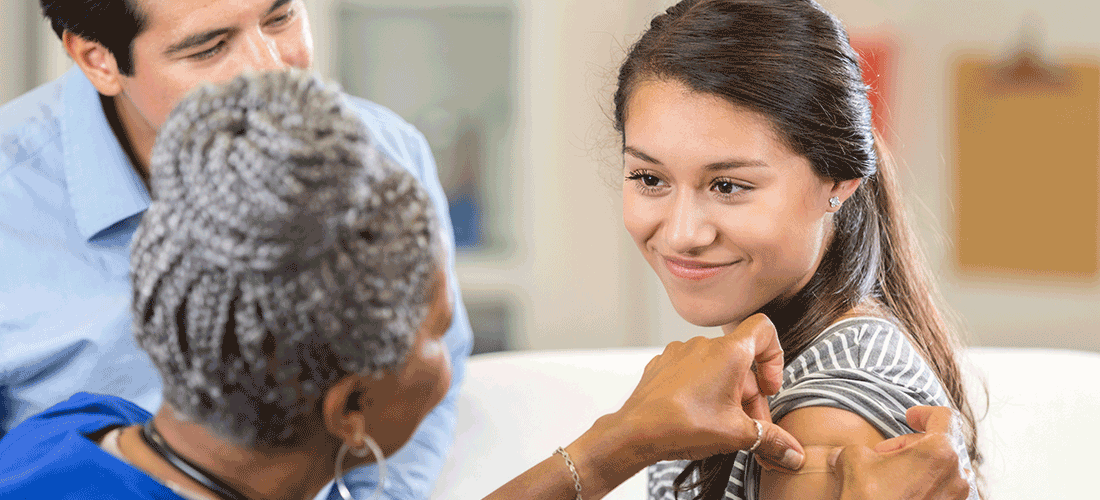 A nurse applying a bandage to a girl