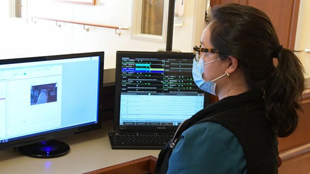 Clinician reviewing data on computer screens