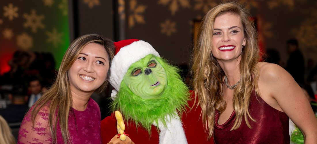Cottage employees posing with the grinch at the Cottage holiday party