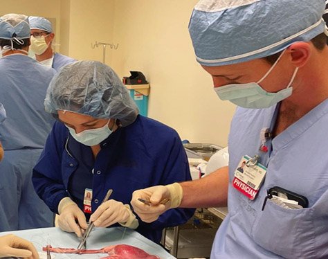 Surgery residents standing at a surgical table