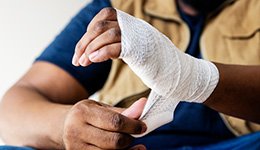 An injured hand being wrapped in gauze