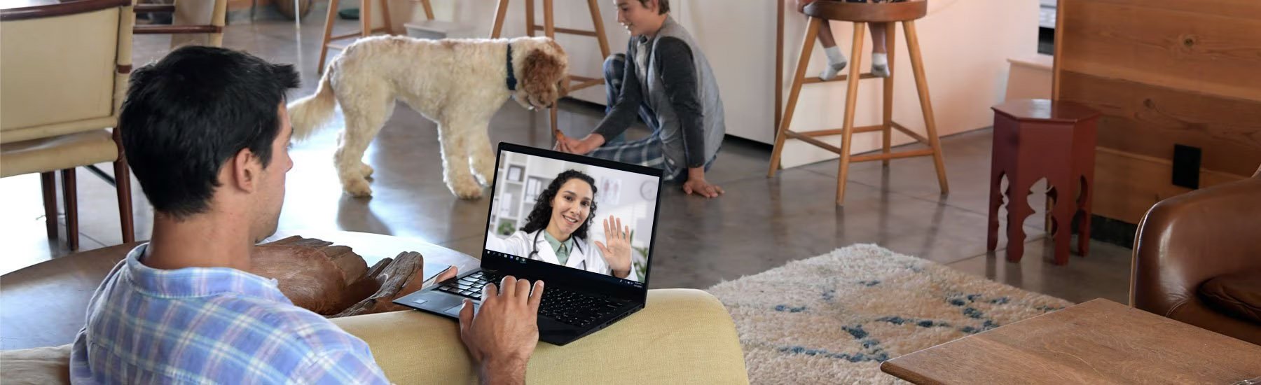 Man with laptop on the couch speaking with a medical provider